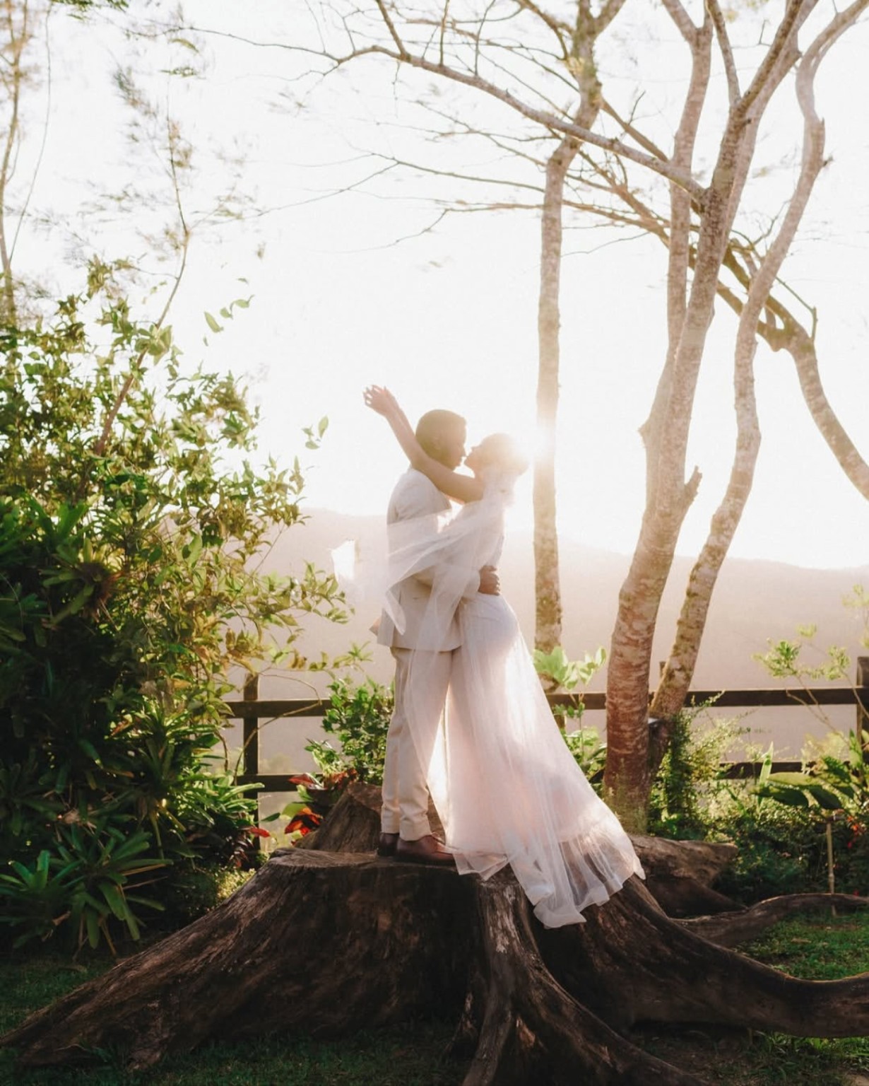 Pareja de novios abrazada entre árboles a contraluz, fotografía de Joel Severino